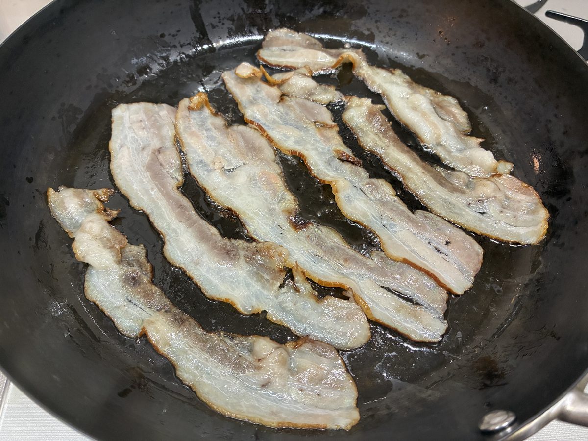 鉄のフライパンで弱火で焼いたサイトウハムの無塩せきベーコン 透明な脂だけが出ていて白い泡が出ていない