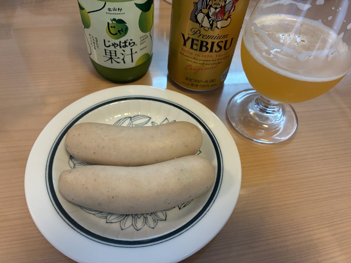 茹でたサイトウハムのヴァイスヴルスト2本を皿に盛りビールとじゃばら果汁を添えたところ